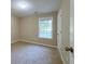Inviting bedroom with neutral carpeting, window, and a door leading to other parts of the house at 413 Old Brock Rd, Rockmart, GA 30153