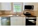 Close-up of a kitchen with stainless steel appliances, white cabinets, and butcher block countertops at 413 Old Brock Rd, Rockmart, GA 30153