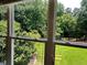 A view of the backyard through a window with trees, sky, and green grass at 4185 Lenox Park Dr, Buford, GA 30519