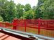 View of backyard with lush trees and a vibrant red deck beyond the window at 4185 Lenox Park Dr, Buford, GA 30519