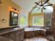 Bathroom with granite countertops, jetted tub, and natural light from large windows at 4185 Lenox Park Dr, Buford, GA 30519