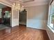 Open dining area with chandelier, hardwood floors, and kitchen view at 4185 Lenox Park Dr, Buford, GA 30519