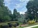 Green home nestled among mature trees and manicured shrubs at 4185 Lenox Park Dr, Buford, GA 30519
