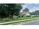Charming green home with stone accents, lush landscaping, and mature trees on a well-manicured lawn at 4185 Lenox Park Dr, Buford, GA 30519