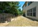 Fenced backyard with a small concrete patio and mature trees providing shade at 574 Friars Head Dr, Suwanee, GA 30024