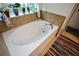 Cozy bathroom with a soaking tub, tile surround and a colorful area rug at 574 Friars Head Dr, Suwanee, GA 30024