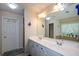 Bright bathroom with dual sinks, tile detail, a big mirror and modern fixtures at 574 Friars Head Dr, Suwanee, GA 30024