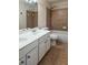Well-lit bathroom featuring a double sink vanity, a bathtub with a shower, and ceramic tile flooring at 574 Friars Head Dr, Suwanee, GA 30024