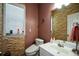 Powder room featuring stylish stone accent wall, bright vanity, and modern toilet for a luxurious touch at 574 Friars Head Dr, Suwanee, GA 30024