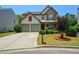 Charming two-story home featuring a manicured lawn, stone accents, and a two-car garage at 574 Friars Head Dr, Suwanee, GA 30024