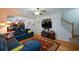 Comfortable living room with a fireplace, hardwood floors, and view into the kitchen at 574 Friars Head Dr, Suwanee, GA 30024