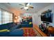 Spacious living room with hardwood floors, ceiling fan and a modern blue sectional couch at 574 Friars Head Dr, Suwanee, GA 30024