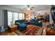 Open living room and kitchen area, showcasing natural light, blue sectional sofa and hardwood floors at 574 Friars Head Dr, Suwanee, GA 30024