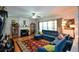Living room featuring a fireplace with wooden floors, a fan, and a large blue sectional sofa at 574 Friars Head Dr, Suwanee, GA 30024