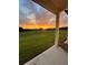 Sunset view of green backyard and distant houses from covered porch at 1611 Alcovy Station Rd, Covington, GA 30014