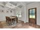 Elegant dining room features coffered ceilings, modern chandelier, wood floors, and a rustic wooden door at 1611 Alcovy Station Rd, Covington, GA 30014