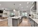 Open concept kitchen boasts an island with seating and pendant lights that opens to the living room at 1611 Alcovy Station Rd, Covington, GA 30014
