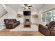 Cozy living room with a brick fireplace, a ceiling fan, and comfortable leather furniture at 1611 Alcovy Station Rd, Covington, GA 30014