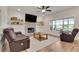 Inviting living room featuring a brick fireplace, a ceiling fan, and large windows offering outdoor views at 1611 Alcovy Station Rd, Covington, GA 30014