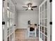 Well-lit home office featuring a rustic wood desk, office chair, and bright natural light, with glass doors at 1611 Alcovy Station Rd, Covington, GA 30014