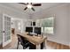 Spacious home office with wood floors, rustic desk, dual monitors, and ample natural light from large windows at 1611 Alcovy Station Rd, Covington, GA 30014
