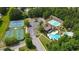 Scenic aerial view of community featuring tennis courts, pickleball, and multiple pools surrounded by lush greenery at 454 Pine Bluff Dr, Dallas, GA 30157