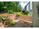 A stone patio and tiered deck lead to a lush green yard with mature trees and a small rock waterfall feature at 454 Pine Bluff Dr, Dallas, GA 30157