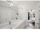 Bright bathroom with dual sinks, marble countertop, and view into bedroom at 454 Pine Bluff Dr, Dallas, GA 30157
