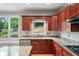 Stylish kitchen with cherry cabinets, granite countertops, and a large window over the sink at 454 Pine Bluff Dr, Dallas, GA 30157