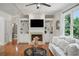 Bright living room featuring a fireplace, built-in shelving, coffered ceilings, and hardwood floors at 454 Pine Bluff Dr, Dallas, GA 30157
