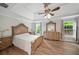 Spacious main bedroom with tray ceilings, ceiling fan, wood floors and large windows with backyard views at 454 Pine Bluff Dr, Dallas, GA 30157