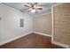 Empty room features wood floors, a modern ceiling fan, and a brick accent wall at 454 Pine Bluff Dr, Dallas, GA 30157