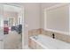 Oversized soaking tub with tile surround and entrance to main bedroom at 570 Mcgarity Dr, Mcdonough, GA 30252