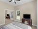 Bright bedroom features a ceiling fan, a window, carpeted floor, and a closet with mirror sliding doors at 570 Mcgarity Dr, Mcdonough, GA 30252