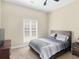 Carpeted bedroom features a ceiling fan, a window, bed with headboard, and a dresser with TV at 570 Mcgarity Dr, Mcdonough, GA 30252