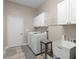 Laundry room with cabinets, a front-loading washer and dryer, sink, drying rod and tiled floor at 570 Mcgarity Dr, Mcdonough, GA 30252