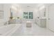 Bright bathroom featuring dual vanities, soaking tub, and white marble flooring at 214 Trecastle Sq, Canton, GA 30114