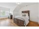 Cozy bedroom featuring a wooden bed frame, hardwood flooring, and window with shutters at 214 Trecastle Sq, Canton, GA 30114