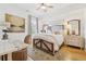 Bright bedroom with a wooden bed frame, ceiling fan, desk, and neutral décor at 214 Trecastle Sq, Canton, GA 30114