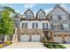 Charming brick and siding townhome with two-car garage and landscaped front, under a sunny sky at 214 Trecastle Sq, Canton, GA 30114
