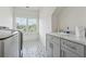 Functional laundry room with patterned tile floors, storage cabinets, and a large sink at 214 Trecastle Sq, Canton, GA 30114