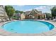 Community pool with plenty of seating and a clubhouse in a well maintained complex under a sunny sky at 214 Trecastle Sq, Canton, GA 30114