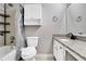 Bathroom featuring granite countertop, white cabinets, combination tub and shower, toilet and vanity at 381 New Jersey Ave Nw, Atlanta, GA 30314