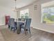 Bright dining room featuring modern gray dining set with a striped rug and large windows at 4323 Cannon Walk, Ellenwood, GA 30294