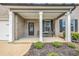 Inviting front porch with decorative columns, seating, and a beautifully landscaped garden at 4323 Cannon Walk, Ellenwood, GA 30294