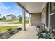 Charming front porch with decorative columns, cozy seating, and landscaped front yard at 4323 Cannon Walk, Ellenwood, GA 30294