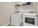 Bright laundry room with a new washer and dryer and a storage shelf at 4323 Cannon Walk, Ellenwood, GA 30294
