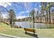 Picturesque lake view featuring mature trees and a wooden bench, creating a peaceful and inviting outdoor space at 52 Sutton Pl, Avondale Estates, GA 30002