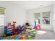Colorful bedroom with a twin bed, play mat, and sunlit windows at 779 Keystone Dr, Woodstock, GA 30188