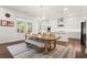 Open-concept dining area complemented by a modern light fixture and a view of the gourmet kitchen at 779 Keystone Dr, Woodstock, GA 30188